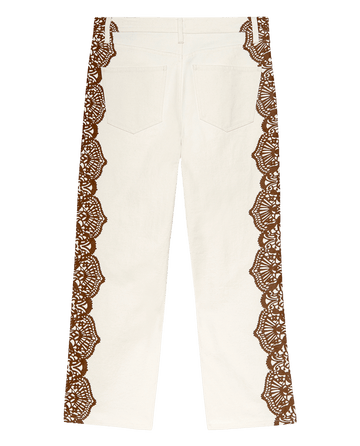 The Lace Print Wayne Jean by THE GREAT. F25 D1 features a cream canvas with brown western lace print along the outer legs and back pockets, shown on a plain background.