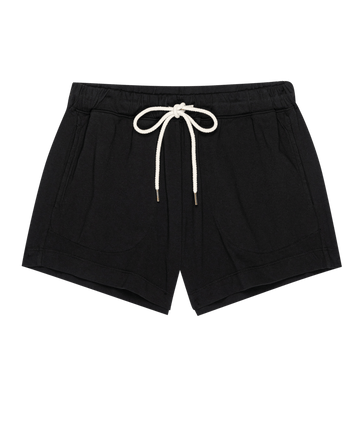 The Flutter Short. -- Almost Black by THE GREAT. PF25 HEAVY JERSEY KNITS: black cotton shorts with a flutter silhouette and front pockets, made in Los Angeles, shown flat on a plain background.