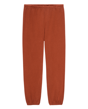 THE GREAT. F25 SEASONAL KNITS' The Stadium Sweatpant in Brick: vintage rust color, elastic waistband and cuffs, handcrafted in Los Angeles, displayed flat on a white background.