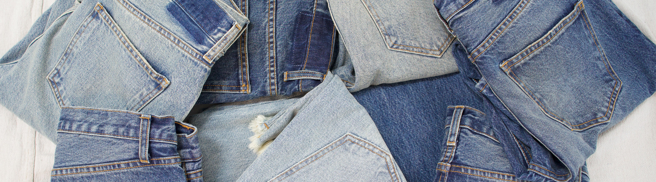 Folded denim pants scattered across the floor.