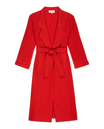 The Trapunto Trench Coat by THE GREAT., in a striking Hot Red, boasts timeless elegance with its notched lapel, waist tie, and long sleeves, capturing the essence of 1950s outerwear.