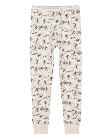 The Union Long John - Slopeside Print by THE GREAT. F25 TGO features cream-colored waffle thermal fabric with a red, green, and blue skier and tree print, elastic waistband, and cuffed ankles—ideal for vintage-inspired layering or standout menswear style.