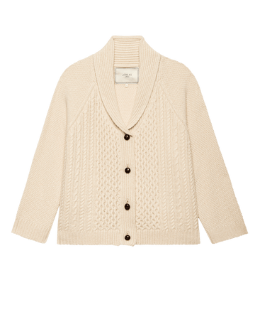 The Cashmere Cable Lodge Cardigan in cream by THE GREAT. F25 COLLECTORS features a shawl collar, front leather button closure, and mixed cable knit patterns on the front.