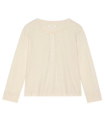 The Crop Sleep Henley in Washed White by THE GREAT. H25 SLEEP is a cozy, long-sleeve jersey shirt crafted from 100% cotton with a round neck and five-button placket, shown laid flat on a white background.