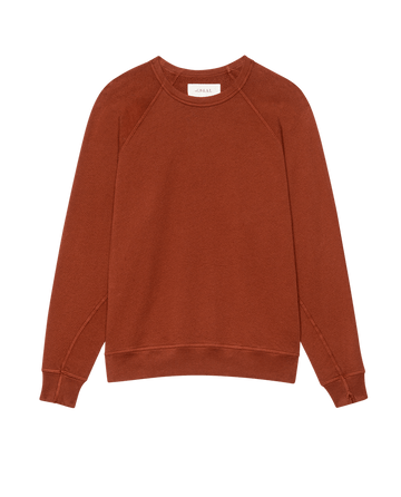 The College Sweatshirt. Solid in Brick by THE GREAT. F25 SEASONAL KNITS features a rust hue, long sleeves, ribbed cuffs, and a straight hem, shown laid flat on a white background.