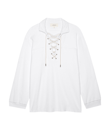 The Micro Terry Lace Up Tunic in True White by THE GREAT. SU25 MICRO TERRY is a long-sleeve shirt with a collar and lace-up front, shown on a plain background.