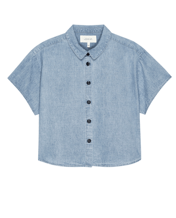 The Valor Top — Boiler Wash by THE GREAT. PF25 is a short-sleeved, light blue denim button-up shirt with a collar, shown against a white background—perfect for elevating your wardrobe.