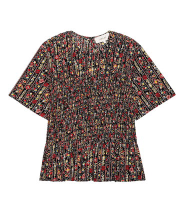 THE GREAT. F25 D2 The Smocked Flounce Top—Garland Print: a short-sleeve floral cotton seersucker top with pleated hem, smocked details, and flounce style, shown flat on a white background.