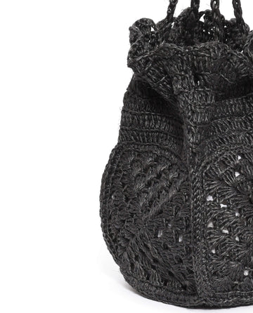 Here's a close-up of The Crochet Drawstring Bag in black, a beautifully hand-woven piece by THE GREAT. SU23. It features an intricate wavy, textured pattern crafted from Agave plant fibers and is highlighted by a gathered, ruffled top edge.