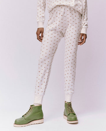A person dressed in The Waffle Long John in White Mini Heirloom Rose from THE GREAT. HOL 24 ROSEBUD CAPSULE, complemented by striking green boots.