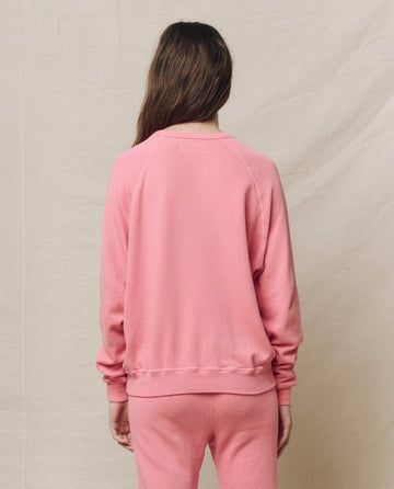 Someone wearing The College Sweatshirt in Solid -- Confetti by THE GREAT. SP25 KNITS stands with their back to the camera against a beige background.