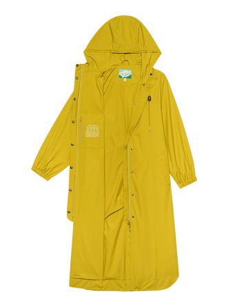 The Rain Trench from THE GREAT. SP25 TGO in Sunshine features a yellow hood and design with front zipper, snap buttons, elastic cuffs, chest pocket pattern, adjustable drawstring, and full spread.