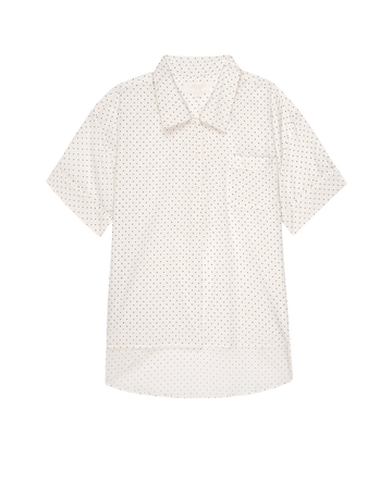 The Short Sleeve Pajama Shirt by THE GREAT. PS25 SLEEP features a sleek black background with mini cream polka dots, a collar, and a single chest pocket.
