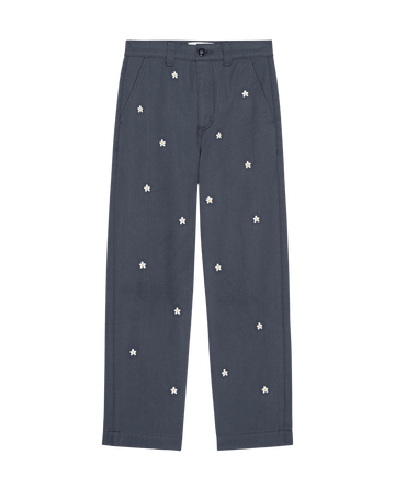 THE GREAT. SP25 D2's The Garage Pant with Daisy Embroidery—Blue Slate features charming white daisies, button and zipper closure, front pockets, and a straight-leg cut.