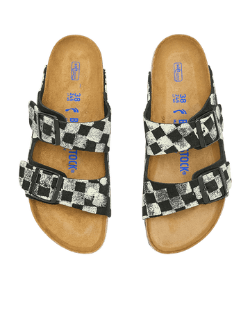 The Hand Stamped Arizona Birkenstock sandals by THE GREAT. HOL 24 BIRKENSTOCK showcase a black with cream checkered pattern and feature two adjustable straps, reminiscent of the classic Arizona style.