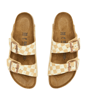 The Hand Stamped Arizona Birkenstock sandals by THE GREAT. HOL 24 BIRKENSTOCK, in Latte with Cream Check, feature a design similar to the classic Arizona style with double straps and side-by-side buckles.