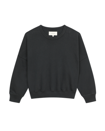 The Teammate Sweatshirt by THE GREAT. FALL21 KNITS is a solid, almost black crewneck featuring vintage details, long sleeves, and a white interior tag.