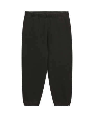 The Little Stadium Sweatpant by THE GREAT. SP22 D2 LITTLE in washed black is crafted from 100% cotton with an elastic waistband and cuffs, exuding vintage athletic charm against a white backdrop.