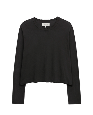The Long Sleeve Crop Tee in Washed Black by THE GREAT. CORE KNITS is a black, long-sleeve cropped tee with a raw hem, ideal for layering, shown on a plain white background.