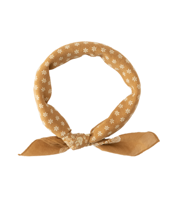 The Bandana. -- Small -- Marigold from THE GREAT. SP24 D2, featuring a brown base adorned with white floral patterns, tied in a knot and made from 100% cotton, exudes the charm of vintage handkerchiefs.