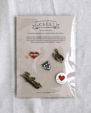 The Great Five Pack Enamel Pins, offered by THE GREAT. HOL 22 ACCESSORIES, is a set of five collegiate-inspired enamel pins in assorted designs, elegantly arranged on a sealed card. The card features the text "THE GREAT. Made with Love," along with a vibrant description of the pin collection in bold colors.