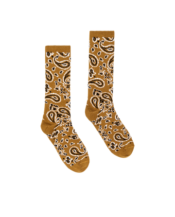 The Bandana Sock in Camel by THE GREAT. H25 COLLECTION is a brown crew sock with a white and black paisley pattern, shown laid flat on a white background.