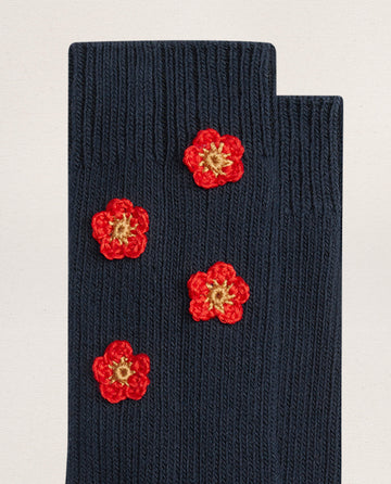 EMME’s THE CROCHET FLOWER SOCK (4 FLOWERS) in navy features dark blue cotton and four small red and yellow hand-crocheted flower appliqués for a charming vintage touch.