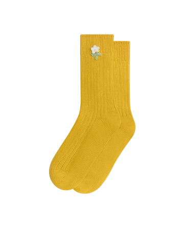 Add vintage charm to any outfit with EMME's THE CROCHET FLOWER SOCK (1 FLOWER) in Marigold—yellow ribbed cotton socks featuring a delicate white hand-crocheted flower near the top.