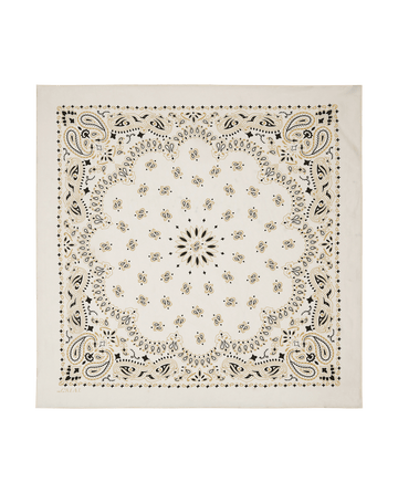 The Silk Bandana – Cream by THE GREAT. F25 COLLECTORS is a square white silk bandana with black and gold paisley and floral patterns, a central scalloped design, and decorative border for a refined, timeless vintage look.