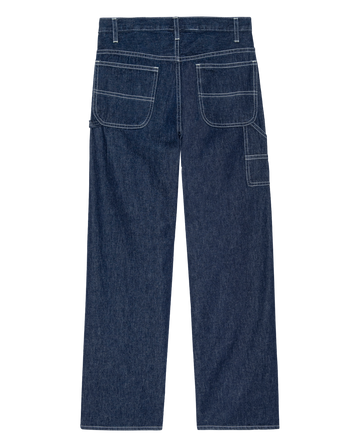 Back view of THE GREAT. PS26 The Mill Jean—Rinse with Cream Stitching, featuring dark blue cotton-hemp denim, white contrast stitching, two large back pockets, a side utility pocket, and wide legs for a relaxed fit.