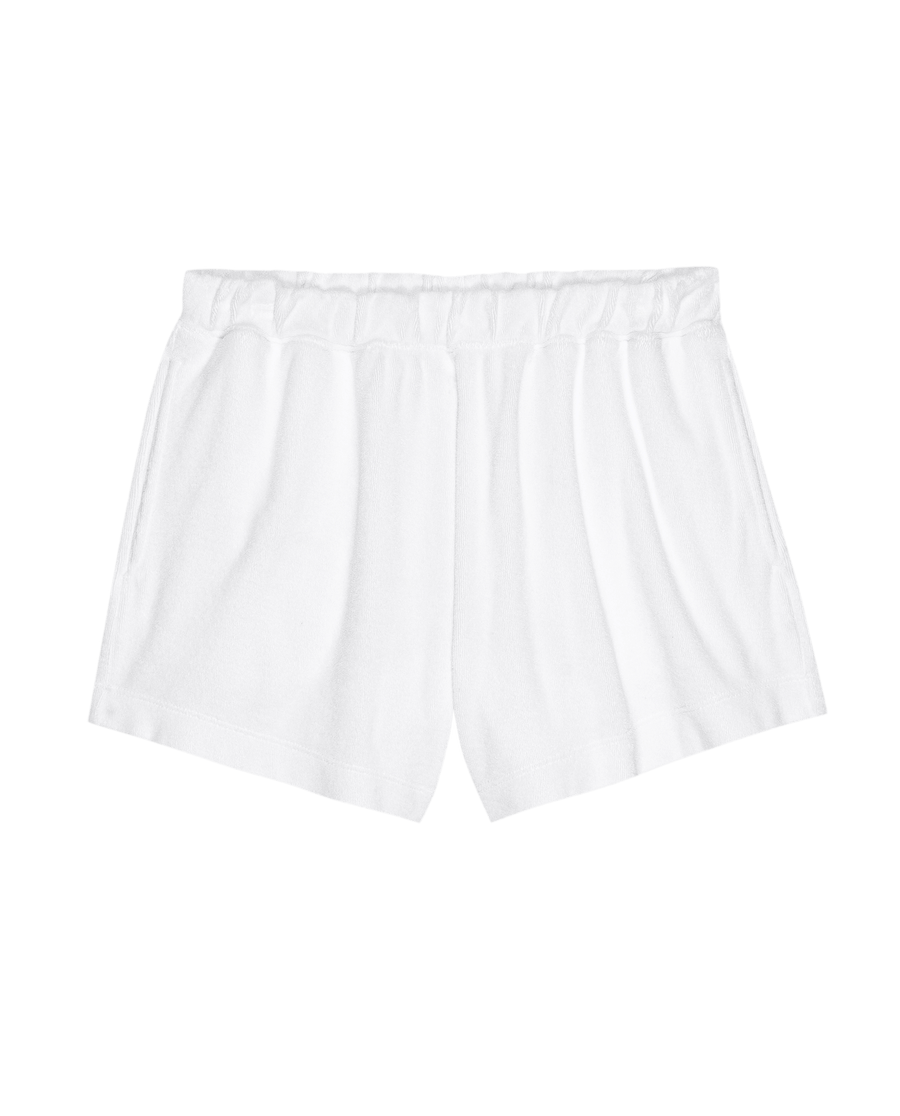 The Micro Terry Swing Short in True White by THE GREAT. SU25 MICRO TERRY features an elastic waistband and is shown against a black background.