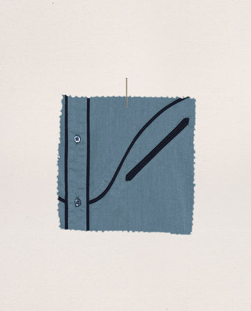 A fabric swatch shows The Western Pajama Shirt—Blue Dusk by THE GREAT. SP25 SLEEP, featuring black piping, two buttons, and a diagonal pocket against a plain light background.