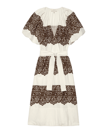 The Fairground Dress by THE GREAT. F25 D1 is a cream, knee-length pullover with short ruffled sleeves, western lace print in brown across the chest, waist, and skirt, plus a matching fabric belt at the waist.