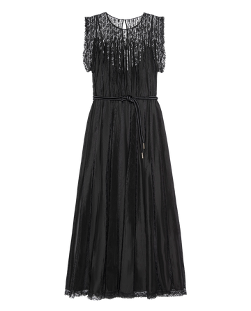 The Keepsake Lace Column Dress in black by THE GREAT. H25 COLLECTION features a sleeveless sheer lace bodice, pleated skirt, lace trim, and a thin waist belt. Shown on a plain white background.