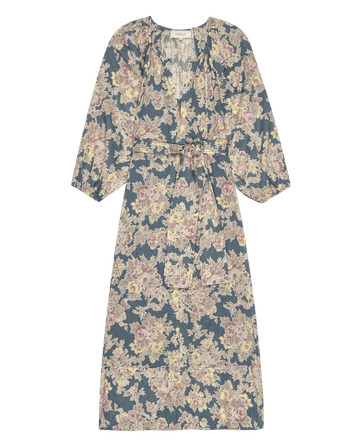 The Pampas Dress by THE GREAT. PF25 is a knee-length, long-sleeve dress with a tie waist, featuring an indigo floral pattern.