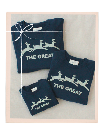 Three navy blue sweatshirts of different sizes, each featuring white reindeer graphics and the text "THE GREAT" on the front, are folded and displayed together.