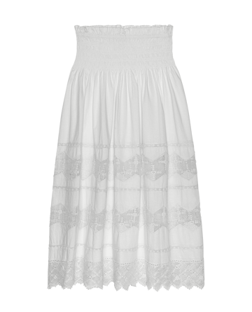 The Rosette Crochet Canary Skirt in cream by THE GREAT. SP26 D2 features a knee-length crochet design with a smocked waistband, lace panels, and scalloped hem, shown against a plain white background.