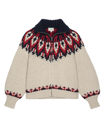 The Nordic Sweater – Glacier Fair Isle by THE GREAT. F25 TGO features beige wool knit with red, black, and white geometric patterns on the shoulders and cuffs, a front zipper, and a dark wide collar.