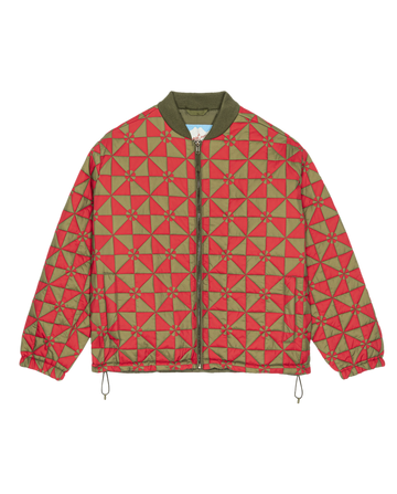 The Alps Puffer Jacket by THE GREAT. F25 TGO features a red and olive green geometric pattern, front zipper, olive collar, and drawstrings at hem and cuffs. Made from recycled polyester for sustainable style. Style: Quilted Vintage Army.