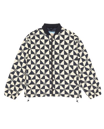 The Alps Puffer Jacket by THE GREAT. F25 TGO is a long-sleeve quilted vintage navy jacket made from recycled polyester, featuring a front zipper and ribbed collar.