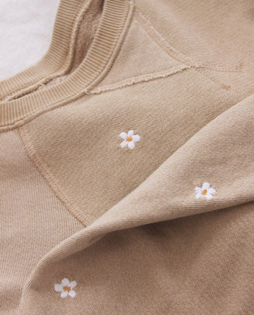 The Slouch Sweatshirt by THE GREAT. PF25 EMB KNITS in khaki features white daisy embroidery scattered across the fabric.