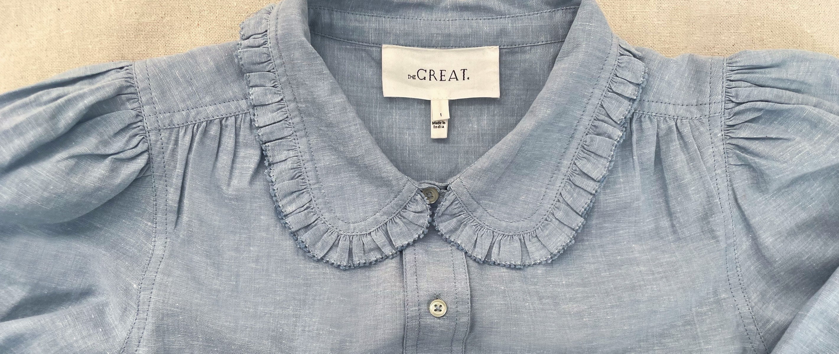 Blue blouse with ruffled collar and "the CREAT" label.