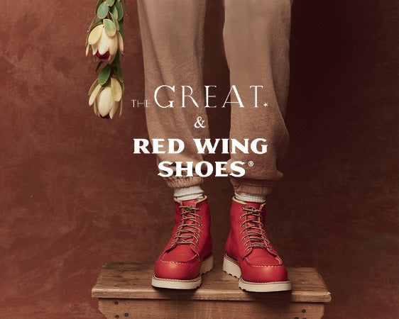 Person wearing red boots and brown pants stands on a wooden platform. They are holding a stem with white flowers. Text overlay reads "The Great & Red Wing Shoes.