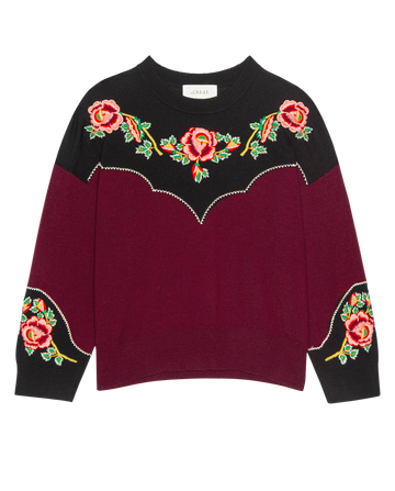 The Heirloom Rose Western Pullover by THE GREAT. H25 COLLECTION in Wine features maroon and black colors with heirloom rose embroidery and red-green accents on the chest, shoulders, and sleeves.