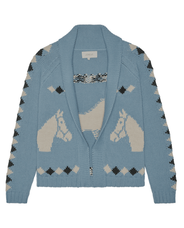 The Stable Lodge Cardigan by THE GREAT. SP26 D1 in Blue Bell features a western horse motif and black and cream geometric accents—a cozy, classic sweater style updated for modern comfort.