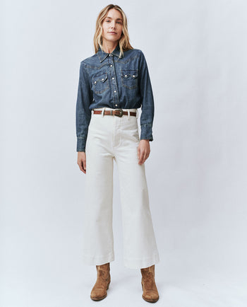 Woman wearing the Seafair pant and a denim button up shirt.