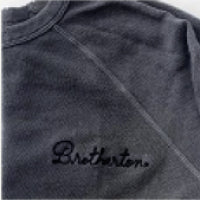 Close-up of a dark gray fabric with the word "Brothers" embroidered in black lettering.
