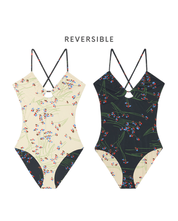 The Reversible Keyhole One Piece—Windblown Bouquet by THE GREAT. SP26 SWIM features cream with red and blue florals on one side, black with matching florals and crisscross straps on the other, offering a versatile reversible style.