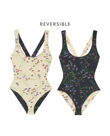Two Reversible Cross-Back One Piece swimsuits by THE GREAT. SP26 SWIM are shown in the Windblown Bouquet print, each featuring a scoop neckline and reversible design: cream floral on one side, black floral on the other.