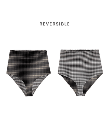 THE GREAT. SP26 SWIM's Reversible High Rise Covered Brief in Black & Cream Check is shown with both black and cream checkered patterns, highlighting a vintage 50s-inspired style against a plain background.